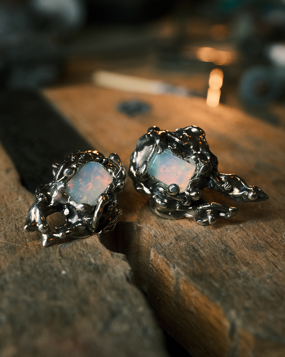 Boucles d’oreilles artisanales en argent 925 avec opales éthiopiennes sur établi en bois style organique marin