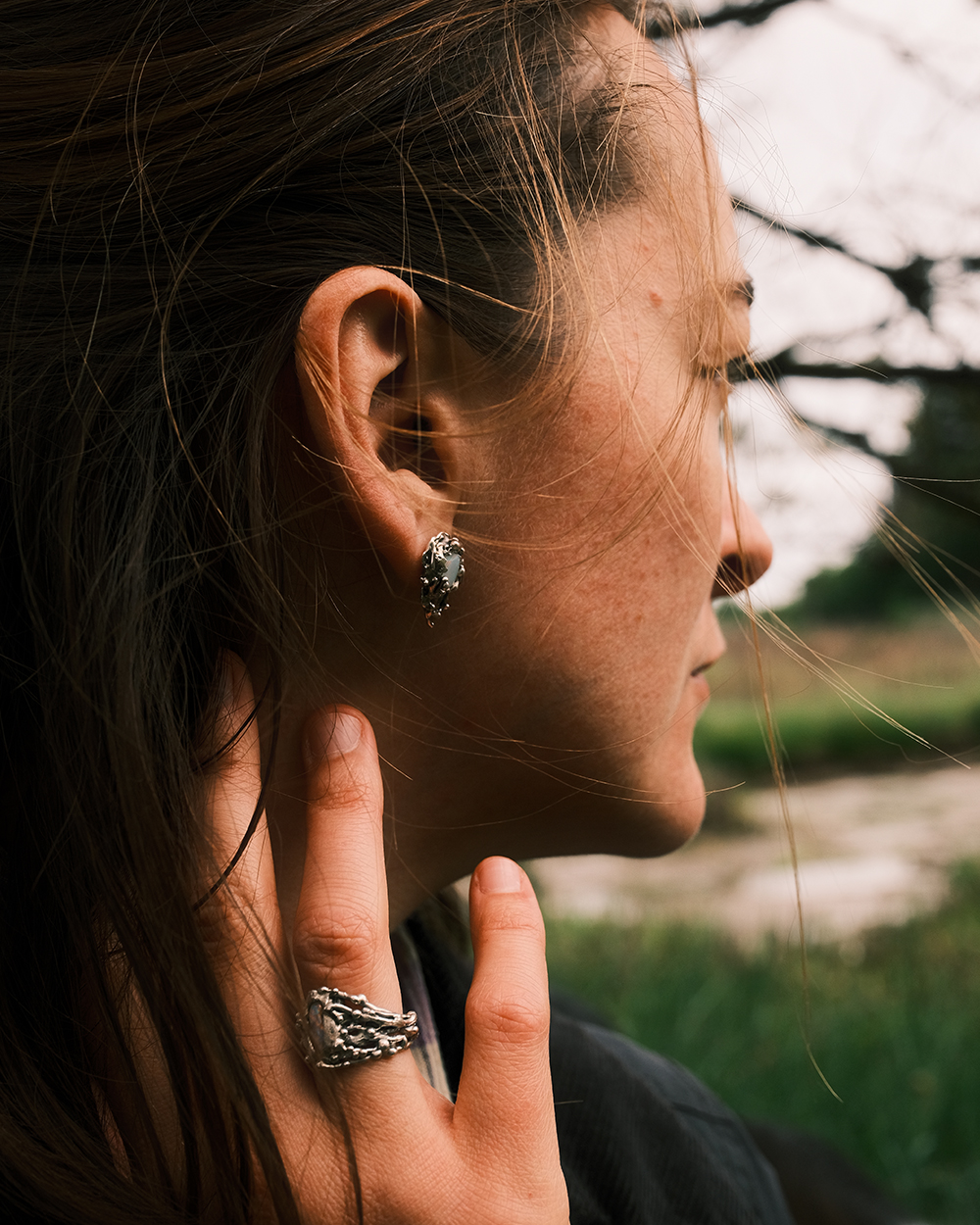 Boucle d’oreille artisanale en argent 925 et opale portée de profil inspiration marine organique