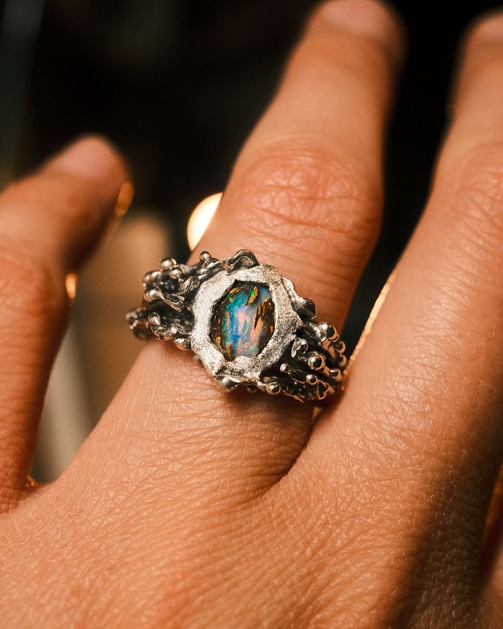 Jungle Aquatique - bague artisanale argent 925 et opale boulder Bague artisanale en argent 925 avec opale boulder aux reflets bleus et verts portée au doigt, design organique inspiré des fonds marins